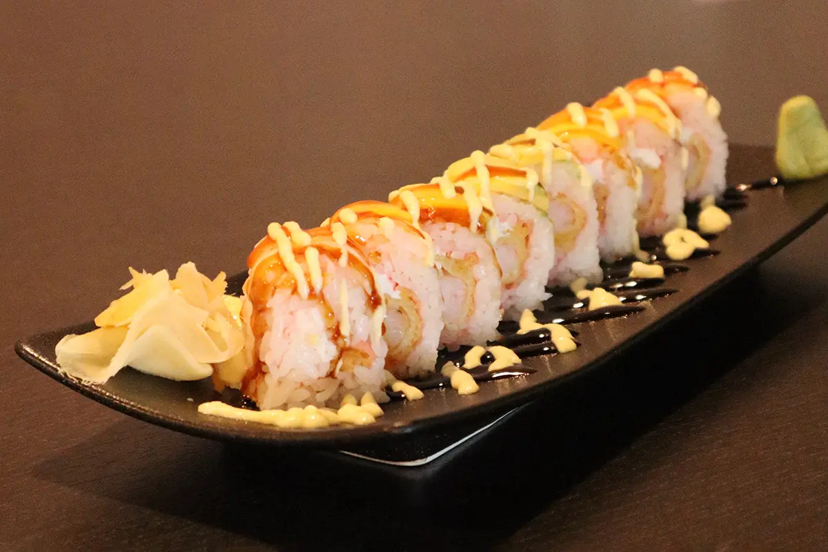 Long - roll sushi on a plate, served with ginger slices at Gyuto Sushi & Ramen，a Japanese Restaurant in Arlington