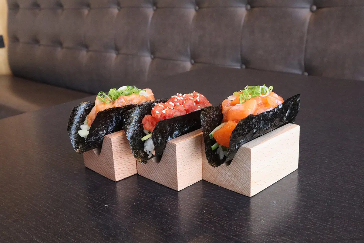 Three kinds of nigiri sushi, placed on wooden blocks at Gyuto Sushi & Ramen，a Japanese Restaurant in Arlington